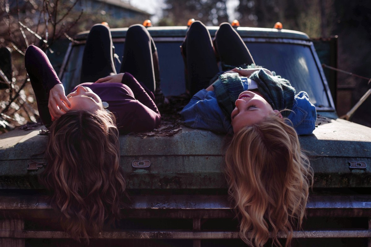 friends lying on car bonnet